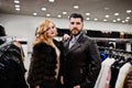 Elegance blonde girl in fur coat and stylish turkish man at the store of fur coats and leather jackets Royalty Free Stock Photo