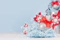 Elegance christmas silver sparkles ball with red silk ribbon on blue gifts paper filler as christmas background in pastel blue. Royalty Free Stock Photo