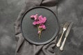 Elegance place setting with pink wildflowers on black table. Top view. Royalty Free Stock Photo