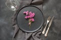 Elegance place setting with pink wildflowers on black table. Top view. Royalty Free Stock Photo