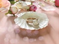 Elegance pearls in seashell ,Jewelry  gold  white pearl rings with seashell and roses petal  on pink  background women acc Royalty Free Stock Photo