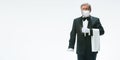 Elegance senior man waiter in protective face mask on white background. Flyer with copyspace.