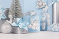 Elegance soft christmas home decorations - silver small fir with blue and metallic gift boxes with shiny ribbons and snowflakes. Royalty Free Stock Photo