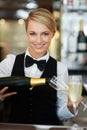 Elegance, style and grace. Portrait of a barmaid pouring champagne for a special celebration. Royalty Free Stock Photo