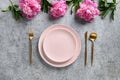 Elegance table setting with peony flowers on grey stone. Top view.