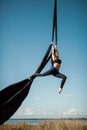 Elegance young beautiful woman dance with aerial silk on a sky background. Fly yoga sport Royalty Free Stock Photo