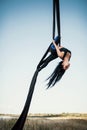 Elegance young beautiful woman dance with aerial silk on a sky background. Fly yoga sport Royalty Free Stock Photo