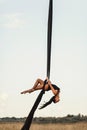 Elegance young beautiful woman dance with aerial silk on a sky background. Fly yoga sport Royalty Free Stock Photo