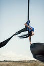 Elegance young beautiful woman dance with aerial silk on a sky background. Fly yoga sport Royalty Free Stock Photo