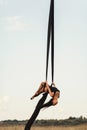 Elegance young beautiful woman dance with aerial silk on a sky background. Fly yoga sport Royalty Free Stock Photo