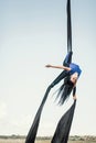 Elegance young beautiful woman dance with aerial silk on a sky background. Fly yoga sport Royalty Free Stock Photo