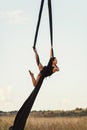 Elegance young beautiful woman dance with aerial silk on a sky background. Fly yoga sport Royalty Free Stock Photo