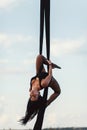 Elegance young beautiful woman dance with aerial silk on a sky background. Fly yoga sport Royalty Free Stock Photo