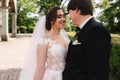 Elegand bride in beautiful white wedding dress with handsome groom in the park. Green background