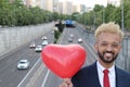 Elegant African American man holding heart ballon in the city Royalty Free Stock Photo