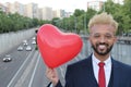 Elegant African American man holding heart ballon in the city Royalty Free Stock Photo