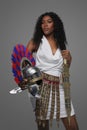 African American woman wears Roman-style gown with an ornate belt hold helmet