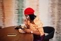 Elegant afro american woman in red french beret, big gold neck chain polka dot blouse pose indoor Royalty Free Stock Photo