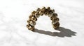 Elegant arch of speckled quail eggs casting a dramatic shadow on a white marble surface, studio shot Royalty Free Stock Photo