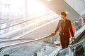 Elegant asian businessman checking email on mobile phone while walking with suitcase Royalty Free Stock Photo