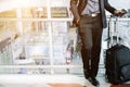 Elegant asian businessman checking email on mobile phone while walking with suitcase Royalty Free Stock Photo