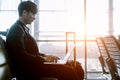 Elegant asian businessman checking email on mobile phone while walking with suitcase inside airport Royalty Free Stock Photo