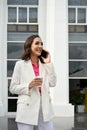 Elegant Asian businesswoman on the phone with her client outside of the building Royalty Free Stock Photo