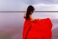 Elegant Woman In Red Silky Dress Walking By A Salt fantastic Lake At Sunset.