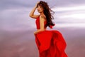 Elegant Asian Woman In Red Dress Walking By A Salt Fantastic Lake At Sunset In Wind.