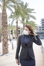 Elegant attractive girl walking on the street with protective mask
