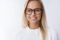 Elegant attractive young businesswoman in glasses smiling delighted, satisfied with new frame of eyewear gazing friendly