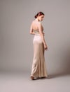 Elegant backless moscato dress. Beautiful ivory silk evening gown. Studio portrait of young ginger woman. Transformer dress idea f