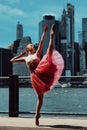 elegant ballerina in dress dancing with New York City downton cityscape on background