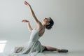 elegant ballerina sitting in white dress