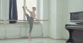 Ballet dancers practicing adagio exercise at barre