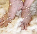 Elegant bare feet wrapped in beautiful pearls Royalty Free Stock Photo