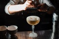 Bartender prepares an alcohol cocktail sour mix, using bar equipment