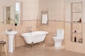 Elegant bathroom interior with luxury vintage bathtub, pedestal sink with a mirror, and toilet Royalty Free Stock Photo