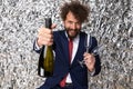 Elegant bearded man with moustache showing and recommending champagne bottle Royalty Free Stock Photo