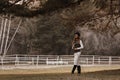 Elegant and beautiful confident young woman wearing stylish jockey outfit is walking and doing dressage Royalty Free Stock Photo