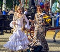 Elegant beautiful women dressed in traditional costumes enjoy April Fair , Seville Fair Feria de Sevilla Royalty Free Stock Photo