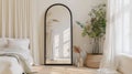 an elegant bedroom adorned with a large black arch mirror, accompanied by a small white wicker basket filled with items