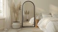 an elegant bedroom adorned with a large black arch mirror, accompanied by a small white wicker basket filled with items
