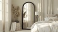 an elegant bedroom adorned with a large black arch mirror, accompanied by a small white wicker basket filled with items