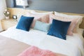 Bedroom interior with comfortable bed with pastel, blue and pink bedding Royalty Free Stock Photo