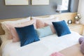 Bedroom interior with comfortable bed with pastel, blue and pink bedding Royalty Free Stock Photo