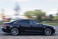 The elegant black Audi A8 is driving on the road at high speed. Motion blur. Riga, Latvia - 28 Jun 2021