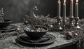 Elegant black dinnerware with candles and silver accents in luxurious table setting Royalty Free Stock Photo