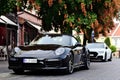 elegant black German made luxury sports car parked along old urban sidewalk. sidewalk cafe. European city. Royalty Free Stock Photo