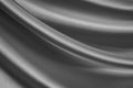 Elegant black and white background. Silver silk satin fabric. Shiny fabric flowing in waves. Close-up. Royalty Free Stock Photo